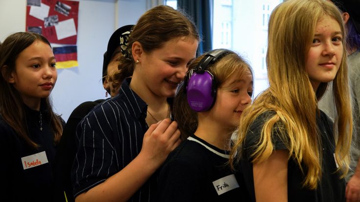 Fem børn på række i klasselokale